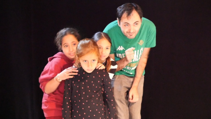 Le-comedien-Jean-Noel-Papera-et-des-ecolieres-en-jeu-au-plateau-lors-des-ateliers-du-projet-S'enforester.